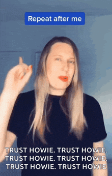 a woman in a black shirt is giving a middle finger and says repeat after me
