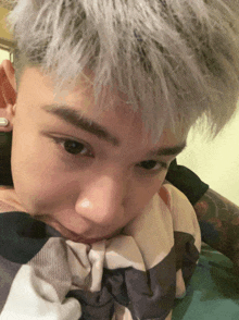a close up of a person 's face with a striped blanket