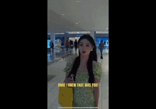 a girl in a green dress is standing in a mall with a man in a red suit .