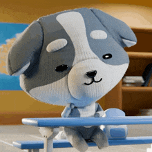 a stuffed dog is sitting on a blue bench with its eyes closed