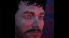 a close up of a man 's face with a beard and blue eyes .
