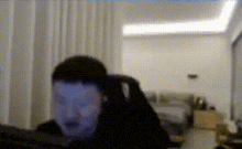 a man is sitting in front of a computer screen in a living room .