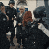 a group of police officers are standing around a woman in a suit