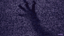 a silhouette of a man in a dark room with a purple light behind him .