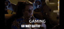 a man is sitting in a chair with speakers on his head and says gaming go way datin '