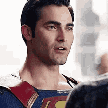 a man in a superman costume is talking to another man in a suit .