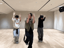 three people are dancing in a room with the word rebels on the bottom right