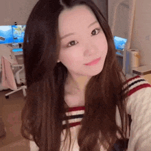 a young woman with long hair is taking a selfie in front of a mirror .