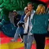 a group of people are standing in front of a giant green monster