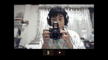 a person wearing headphones is holding a canon camera