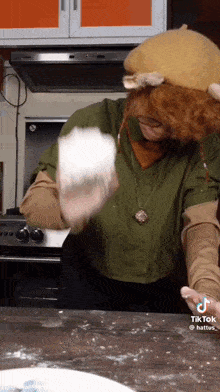 a woman in a costume is throwing a ball of flour in the air .