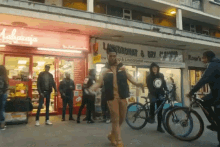 a group of people are walking in front of a maharaja laundromat and dry cleaning store