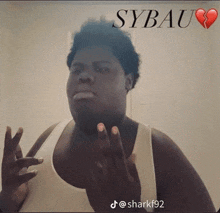 a man in a white tank top is making a funny face with sybau written on the bottom