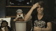 a man in a black shirt with skulls on it is holding a stuffed animal