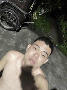a shirtless man is taking a selfie in front of a cart