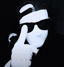 a man wearing sunglasses and a white mask is making a thumbs up sign