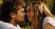 a man and a woman are touching noses and smiling