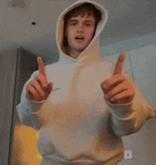 a man in a hoodie is giving a thumbs up sign