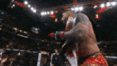 a man in a boxing ring holding a canadian flag and a championship belt