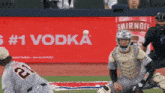 a smirnoff ad is behind a baseball field