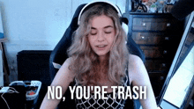 a woman wearing headphones is saying no , you 're trash .