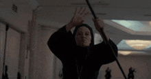 a silhouette of a person holding a sword in a room