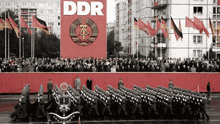 soldiers march in front of a sign that says ddr on it