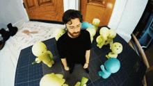 a man with a beard is surrounded by stuffed animals with faces on them