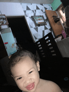 a baby is smiling in front of a digital clock that says the time is 7:26