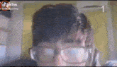 a man wearing glasses and headphones looks at the camera .