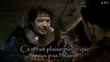 a man in armor is talking to a woman and the words ca mi fait plaisir are visible