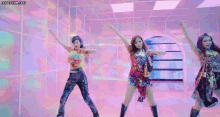a group of girls are dancing in a room with a colorful background .