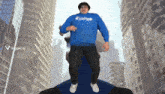 a man in a blue sweatshirt with the word raiders on it is jumping in the air