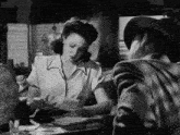 a man and a woman are sitting at a table in a diner