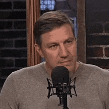 a man is sitting in front of a microphone .