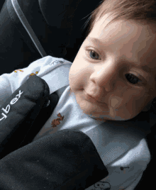 a baby wearing a snoopy outfit is sitting in a car seat with the word cybex on it