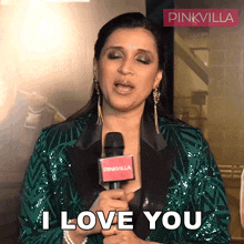 a woman in a green jacket is holding a microphone and saying i love you