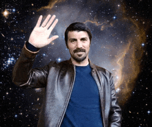 a man in a leather jacket is waving in front of a galaxy
