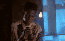 a man in a suit and tie is holding a lighter in his hand in front of a window .