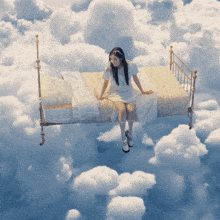 a woman is sitting on a bed in the sky