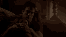 a man and a woman are laying on a couch and hugging