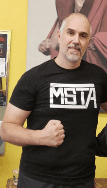 a man wearing a black shirt that says msta