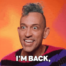 a man with a mohawk and a sweater that says i 'm back