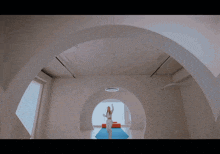 a woman walking down a blue carpeted hallway
