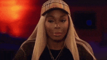 a woman with long blonde hair is wearing a plaid hat and a necklace .