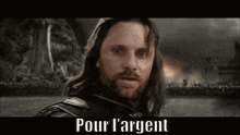 a man with a beard and long hair is standing in front of a sign that says pour l' argent