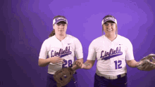 two female softball players from the linfield team shake hands