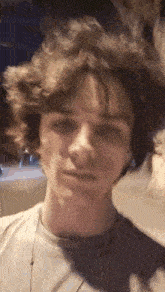 a close up of a young man 's face with his hair blowing in the wind .
