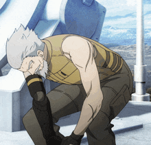 a man with a beard is kneeling down with his hands on his head