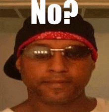 a man wearing sunglasses and a bandana has the word no on his hat